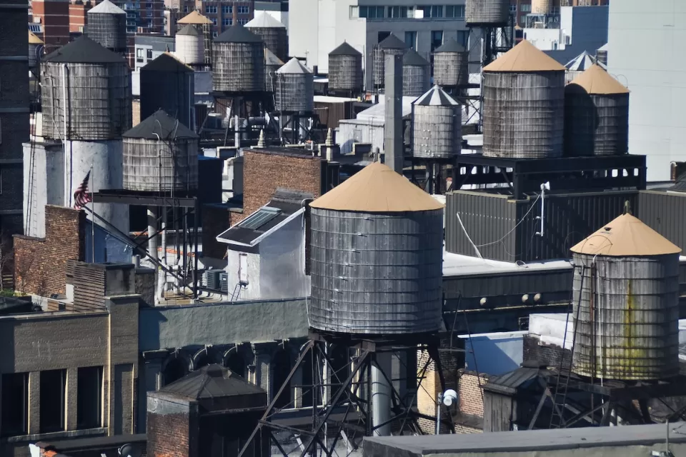 Old water towers on dense New York City rooftops.